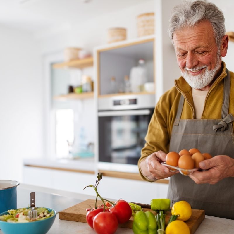 Mature handsome man cooking in home kitchen