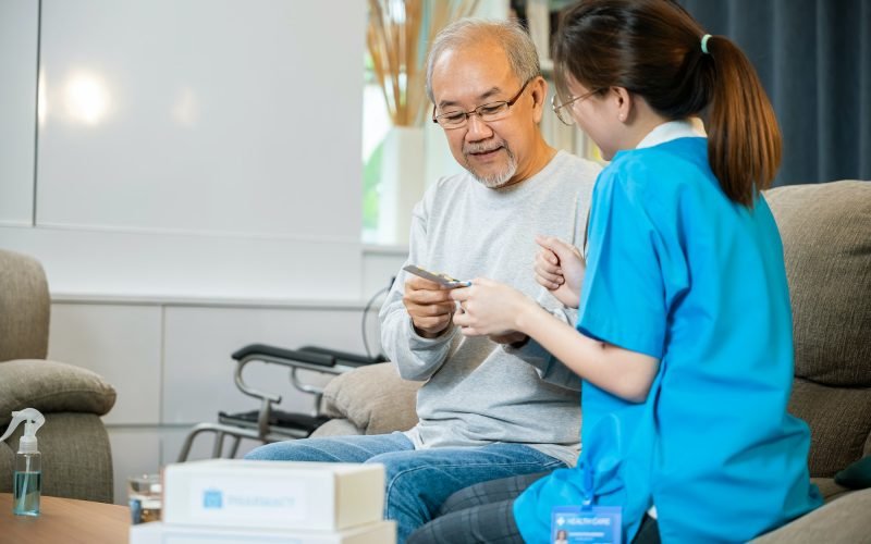 woman-nurse-caregiver-showing-prescription-drug-to-senior-man-at-nursing-home.jpg